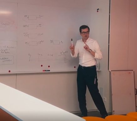 Teammitglied erklärt eine Systemarchitektur am Whiteboard