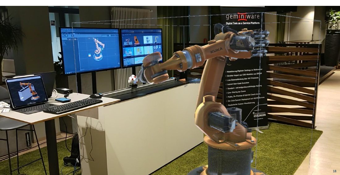 Messestand mit Industrieroboter und Digitalem Zwilling auf Bildschirmen