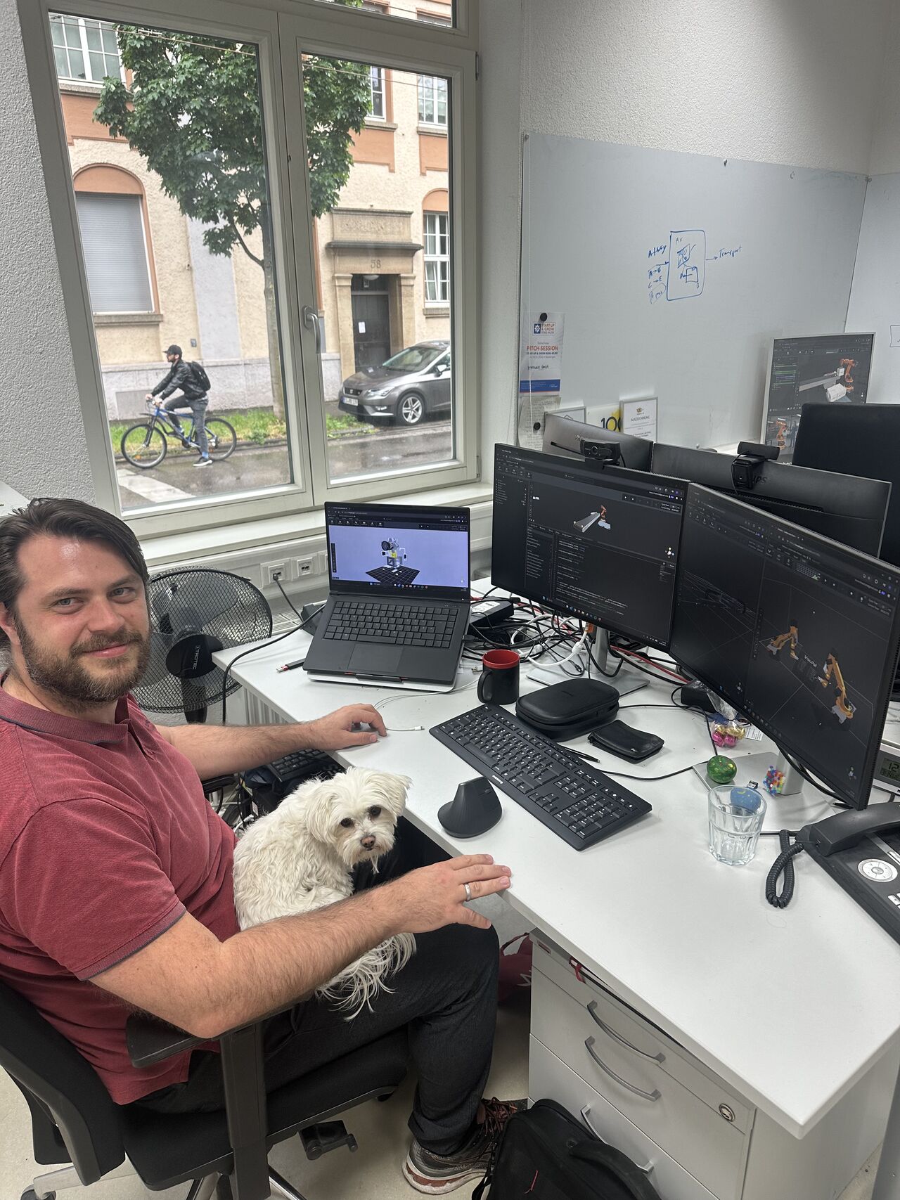 Entwickler am Arbeitsplatz mit 3D-Modellen auf mehreren Bildschirmen